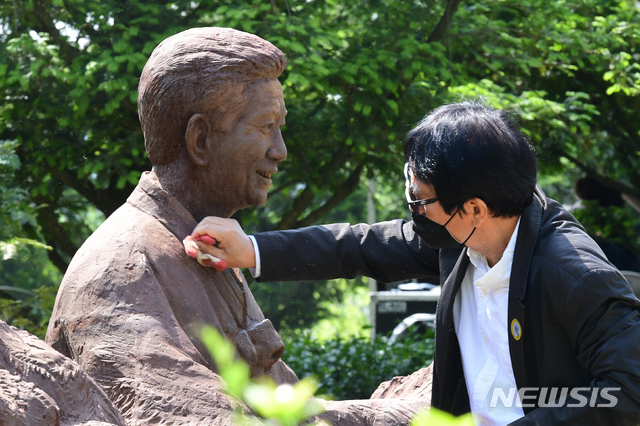 [김해=뉴시스] 차용현 기자 = 23일 오전 경남 김해시 진영읍 본산리 봉하마을 대통령묘역에서 열린 노무현 전 대통령 서거 11주기 공식 추도식에서 한 남성이 노 전 대통령의 흉상을 닦고 있다. 2020.05.23.&nbsp;&nbsp; con@newsis.com