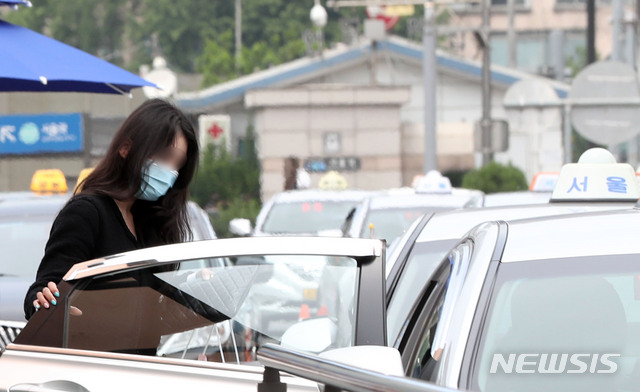 [서울=뉴시스] 박미소 기자 = 정부가 오는 26일부터 승객이 버스나 택시를 탈 때 운송사업자와 운수종사자가 마스크를 착용하지 않을 경우 관할 시·도지사가 개선 조치를 내리도록 한 25일 오후 서울 용산구 서울역 인근 택시 정류장에서 시민들이 마스크를 쓰고 택시에 탑승하고 있다. 2020.05.25. misocamera@newsis.com