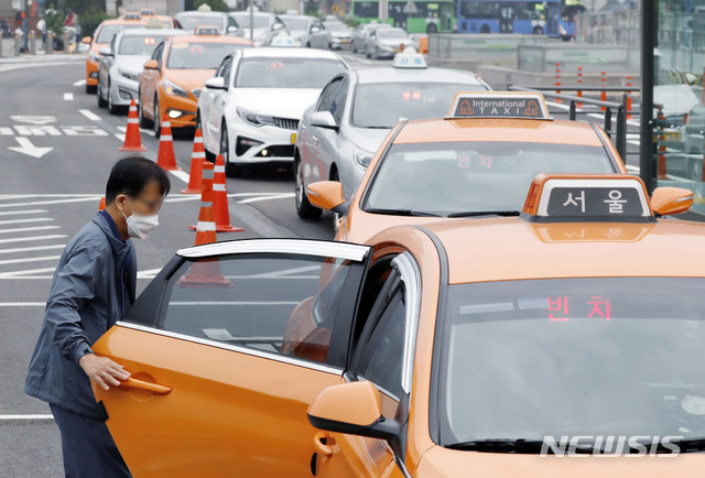 [서울=뉴시스] 최동준 기자 = 서울역 앞에서 한 시민이 마스크를 착용하고 택시를 이용하고 있다. 2020.05.26. photocdj@newsis.com