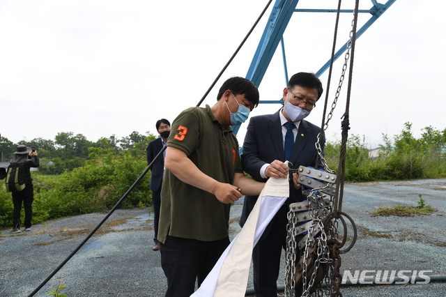 [서울=뉴시스] 조수정 기자 = 서호 통일부 차관이 26일 문화재청 비무장지대(DMZ) 유네스코 세계유산 등재 실태조사단과 함께 판문점 인근 대성동 마을을 방문, 태극기 교체를 돕고 있다. (사진=통일부 제공) 2020.05.26. photo@newsis.com
