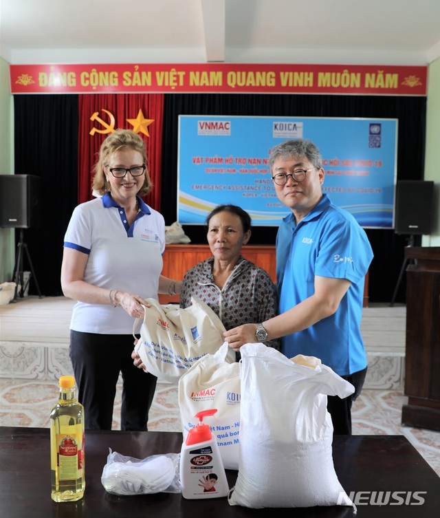 [서울=뉴시스] 코이카 베트남 사무소는 25일부터 27일까지 3일간 코로나19 확산으로 어려움을 겪는 베트남 불발탄 피해자를 돕기 위해 13만 달러(1억6000만원) 상당의 방역물품과 긴급 식량을 지원했다. 왼쪽부터 케이트린 위젠(Caitlin Wiesen) UNDP 베트남 사무소장, 불발탄 피해자, 조한덕 코이카 베트남 사무소장. (사진/코이카 제공) photo@newsis.com