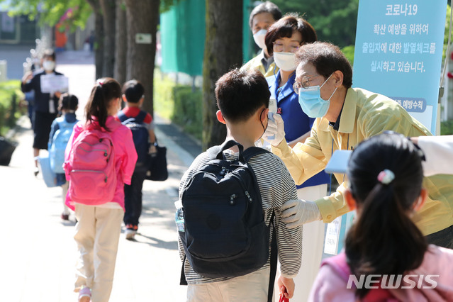 [서울=뉴시스] 박미소 기자 = 전국 고등학교 2학년, 중학교 3학년, 초등학교 1·2학년과 유치원생이 등교해 교실에서 수업을 받는 27일 오전 서울 송파구 세륜초등학교에서 조희연 서울시교육감이 등교하는 초등학생들에게 발열체크를 하고 있다. 2020.05.27. misocamera@newsis.com