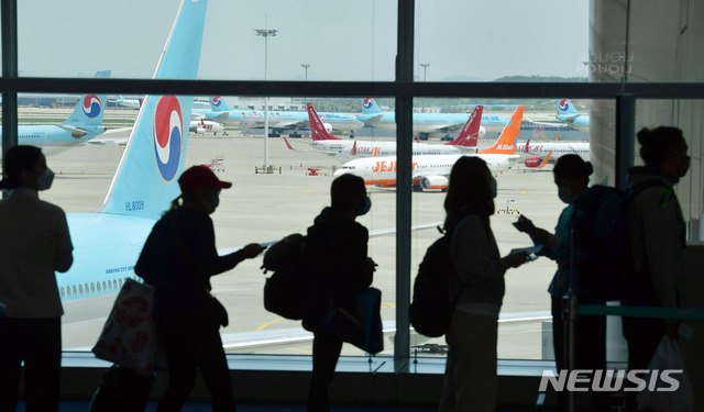 [인천공항=뉴시스] 고범준 기자 = 신종 코로나바이러스 감염증(코로나19) 확산을 막기 위해 국내·국제선 항공기 탑승객들의 마스크 착용 의무화 조치가 적용된 지난해 5월27일 인천국제공항 제2터미널 출국장에서 런던으로 출발하는 승객들이 마스크를 쓰고 비행기에 탑승하고 있다. 2021.01.16 bjko@newsis.com