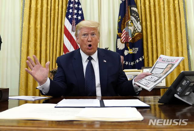 [워싱턴=AP/뉴시스]도널드 트럼프 미국 대통령이 28일(현지시간) 백악관 집무실에서 트위터 등 소셜미디어와 온라인 플랫폼 규제 행정명령에 서명하기 전 트위터에 관해 보도한 뉴욕포스트를 들어 보이고 있다. 이번 행정명령은 게시글과 관련해 소셜미디어와 온라인 플랫폼에 제공되던 광범위한 법적 보호를 제한하는 내용을 담고 있는 것으로 트위터가 트럼프 대통령의 게시물에 '팩트체크' 경고문을 붙인 지 하루 만에 나온 조치다. 2020.05.29. 