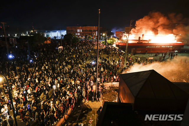 [미네아폴리스=AP/뉴시스] 미국 미네소타주 미네아폴리스에서 29일(현지시간) 불타고 있는 경찰서 앞에서 경찰의 비무장 흑인 남성 살해 사건에 항의하는 시위가 벌어지고 있다. 2020.05.29 