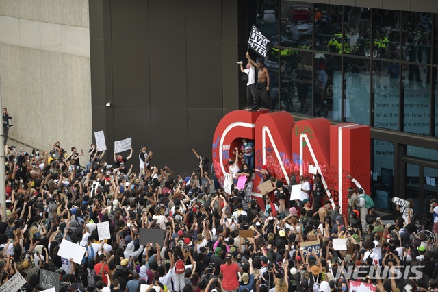 [애틀랜타= AP/뉴시스] 29일(현지시간) 미국 조지아주 애틀랜타에 위치한 CNN 본사에서 시위대가 "흑인의 목숨도 중요하다(Black lives matter)" 구호가 적힌 깃발을 들고 있다. 비무장 상태로 경찰에게 목이 짓눌려 사망한 흑인 조지 플로이드 사건에 항의하는 시위가 이날 미 전역에서 열렸다. 2020.05.30. 