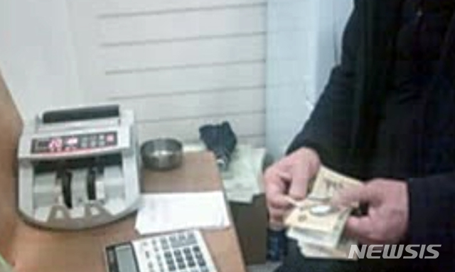 [광주=뉴시스] 변재훈 기자 = 정부가 전통시장 활성화를 위해 발행한 온누리상품권을 조직적으로 사들여 불법 현금화하는 사설 환전소 운영 실태가 담긴 동영상이 31일 입수됐다. 입수 영상 속에는 지난 2월 초 광주 서구 한 전통시장 내 사무실에서 대량 매집한 온누리상품권과 거액의 현금을 맞바꾸는 모습이 담겼다. (사진 = 독자 제공 동영상 캡쳐) 2020.05.31.photo@newsis.com