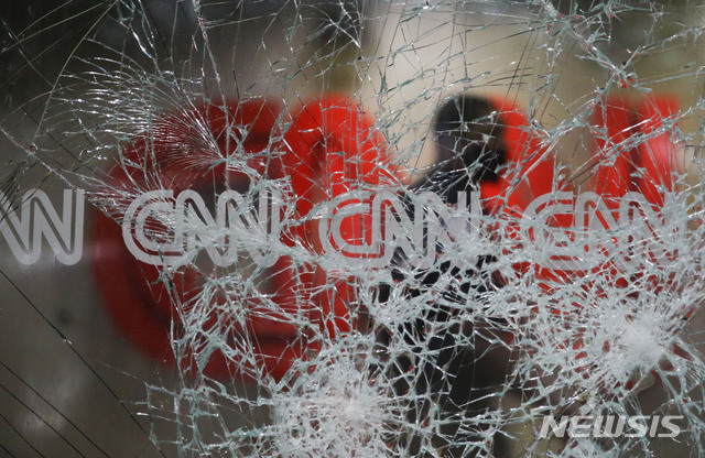 [ 애틀랜타( 미 조지아주)= AP/뉴시스] 주말 시위로 파괴된 애틀랜타 CNN지국 유리창 안쪽에서 경비원이 건물을 지키고 있다. 미니애폴리스 경찰의 비무장 흑인 살해에 격분한 시위군중이 30일 전국에서 폭력적인 시위를 벌였다.&nbsp; 