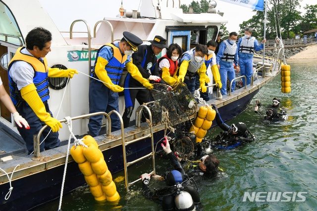 [서울=뉴시스]포스코가 지난 29일 광양시 태인동 배알도 수변공원 일원에서 광양시와 함께 신종 코로나바이러스 감염증(코로나19) 생활 속 거리두기를 준수하면서 해양환경 정화활동을 펼쳤다. 최정우 회장과 클린오션봉사단이 함께 배알도 수변공원에서 플라스틱, 폐그물 등 수중쓰레기를 수거하고 있다. 2020.05.31 (사진 = 포스코 제공) photo@newsis.com