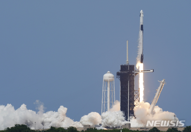 [케이프커내버럴=AP/뉴시스]미 항공우주국(NASA) 우주비행사 더글러스 헐리와 로버트 벤킨이 크루 드래건에 탑승한 스페이스X 팰컨9호가 30일(현지시간) 미 플로리다주 케이프 커내버럴의 케네디 우주센터 39-A 발사대에서 발사되고 있다. 팰컨9는 테슬라 최고경영자(CEO) 일론 머스크가 설립한 우주탐사 기업 스페이스X가 민간기업 최초로 발사한 민간 유인 우주선으로 민간 우주여행 시대의 새로운 이정표를 세웠다. 2020.05.31.