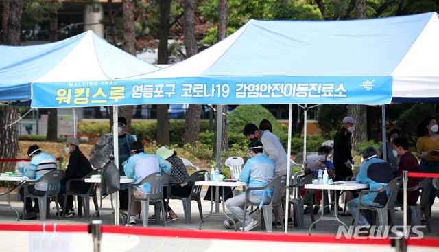 [서울=뉴시스]김선웅 기자 = 여의도 학원발 코로나19 확산이 우려되는 가운데 31일 서울 여의도 자매근린공원에 설치된 코로나19 선별진료소에서 의료진이 분주히 움직이고 있다. 2020.05.31.mangusta@newsis.com