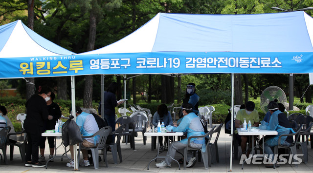 [서울=뉴시스]김선웅 기자 = 여의도 학원발 코로나19 확산이 우려되는 가운데 31일 서울 여의도 자매근린공원에 설치된 코로나19 선별진료소에서 의료진이 분주히 움직이고 있다. 2020.05.31.mangusta@newsis.com