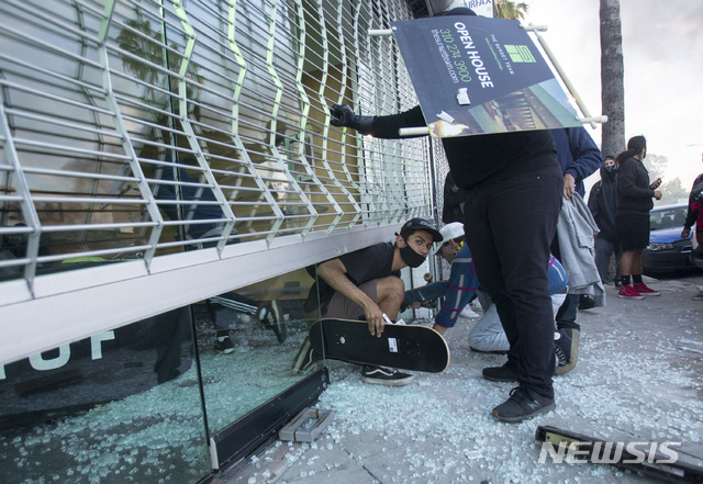 [로스앤젤레스=AP/뉴시스]5월30일(현지시간) 미국 캘리포니아주 로스앤젤레스에서 일부 시위대가 상점에 무단 침입해 물건을 훔치고 있다. 미국에서는 백인 경찰에게 목이 짓눌려 사망한 흑인 조지 플로이드 사건을 규탄하는 시위가 격렬해지고 있다. 2020.06.05