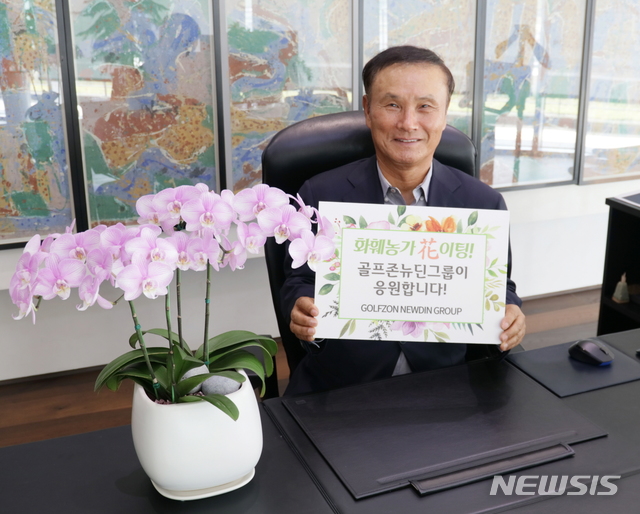 [서울=뉴시스]골프존뉴딘그룹 김영찬 회장이 지난달 29일 코로나19 여파로 어려움을 겪는 화훼농가를 위해 ‘화훼농가 돕기 릴레이 캠페인’에 참여해 응원문구를 들고 기념찰영을 하고 있다.(사진=골프존뉴딘그룹 제공)