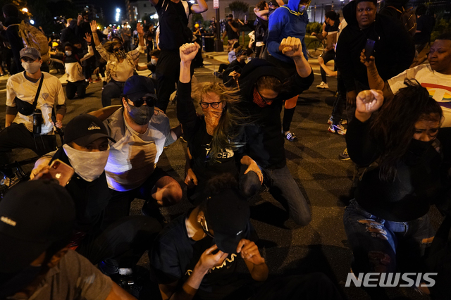 [워싱턴=AP/뉴시스]1일(현지시간) 미국 워싱턴 백악관 주변에서 조지 플로이드의 죽음에 항의하는 시위대를 향해 헬리콥터가 낮게 날아들자 시위대의 머리가 흩날리고 있다. 2020.06.02.