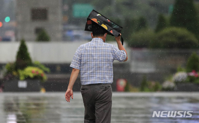 [서울=뉴시스] 박민석 기자 = 서울 지역에 비가 내린 지난 2일 서울 종로구 광화문광장에서 우산을 챙기지 못해 가방을 머리에 쓴 시민이 걷고 있다. 2020.06.02. mspark@newsis.com
