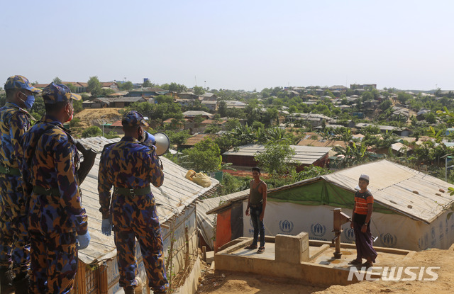 [콕스바자르=AP/뉴시스]2일(현지시간) 방글라데시 당국은 100만 명 이상의 로힝야 난민이 거주하는 콕스 바자르 난민촌에 로힝야족 난민 중 첫 코로나19 사망 사례가 발생했다고 밝혔다.사진은 지난달 15일 콕스 바자르의 로힝야 난민촌에서 한 보안 요원이 코로나19 예방을 위해 사회적 거리 두기 실천을 강조하는 모습. 2020.06.02. 
