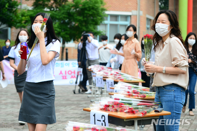 [청주=뉴시스] 인진연 기자 = 3차 순환등교가 시작된 3일 오전, 충북 청주 흥덕고등학교 교사들이 하복을 입고 첫 등교하는 신입생들에게 환영하는 의미를 담아 꽃을 건네고 있다. 이날 충북에서는 초 3·4, 중2, 고1 등 약 5만5000여 명이 첫 등교에 나섰다. 2020.06.03inphoto@newsis.com