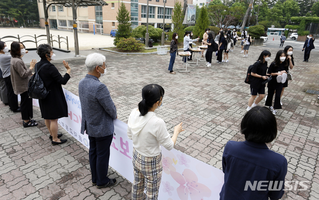 [청주=뉴시스] 인진연 기자 = 3차 순환등교가 시작된 3일 오전, 충북 청주 흥덕고등학교 교사들이 하복을 입고 첫 등교하는 신입생들에게 반갑게 손을 흔들고 있다. 이날 충북에서는 초 3·4, 중2, 고1 등 약 5만5000여 명이 첫 등교에 나섰다. 2020.06.03 inphoto@newsis.com