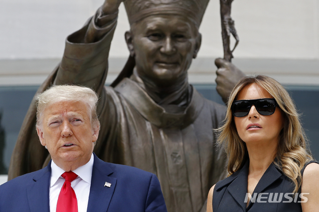 [워싱턴=AP/뉴시스]도널드 트럼프 미국 대통령과 부인 멜라니아 여사가 2일(현지시간) 미 워싱턴DC 내 성 요한 바오로 2세 국가 성지를 방문해 동상 앞에 헌화 후 기념촬영을 하고 있다. 멜라니아 여사는 이날 기념촬영을 하면서 트럼프 대통령의 웃어달라는 요청에 불편한 기색을 보인 것으로 전해졌다. 웃으며 사진을 찍던 트럼프 대통령이 멜라니아에게 "좀 웃지 그래?"(Can you please smile?)라고 하자 멜라니아 여사는 억지로 웃는 표정을 짓고 이내 무뚝뚝한 모습으로 돌아왔으며 이 장면은 SNS를 통해 퍼지고 있다. 2020.06.03.&nbsp; 