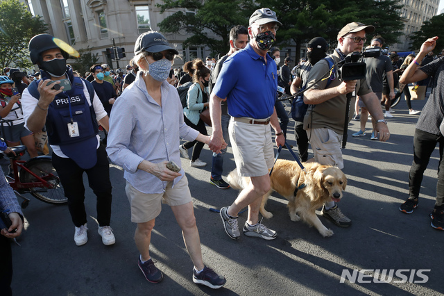 [워싱턴=AP/뉴시스]미국 민주당 대선 후보로 나섰던 엘리자베스 워런 상원의원(맨 앞)이 2일(현지시간) 백악관 인근에서 열린 조지 플로이드 사망 규탄 시위에 참여한 모습. 그의 옆으로 역시 시위에 참여한 배우자 브루스 만과 반려견 베일리도 보인다. 2020.06.03.