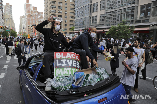 [뉴욕=AP/뉴시스] 2일(현지시간) 미국 뉴욕시에서 열린 플로이드 사망 항의시위 도중 차량에 탄 이들이 시위대들에게 물과 먹거리를 나눠주고 있다. 뉴욕시는 2일(현지시간), 전날부터 실시했던 통행금지 조치를 7일까지 연장하고 통행금지 시간도 오후 8시부터 다음날 오전 5시까지 확대했다. 