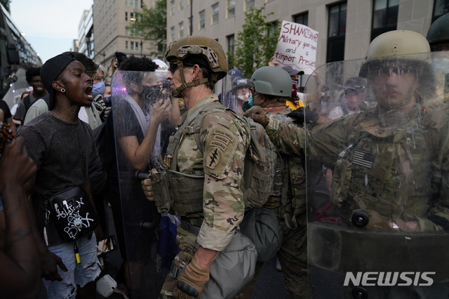 [워싱턴=AP/뉴시스]지난 6월3일(현지시간) 미국 워싱턴 백악관 근처에서 조지 플로이드 사망에 항의하는 시위대가 유타주방위군과 대치하고 있다. 2020.10.31 