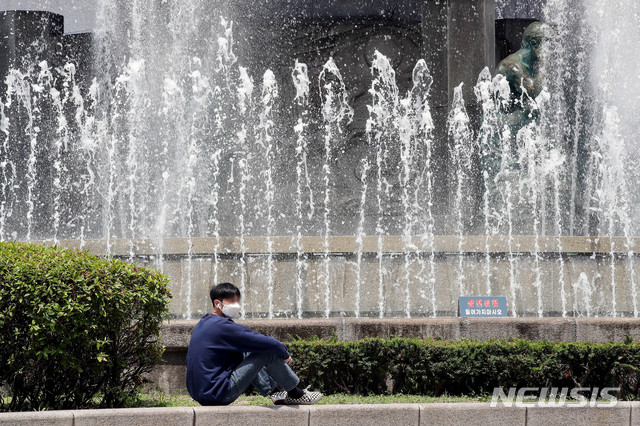 [서울=뉴시스]김병문 기자 = 대구 등 경상 내륙지역에 올해 첫 폭염특보가 내려진 4일 오후 서울 중구 신세계백화점 본점 앞 분수대에서 한 시민이 더위를 피하고 있다. 2020.06.04. dadazon@newsis.com