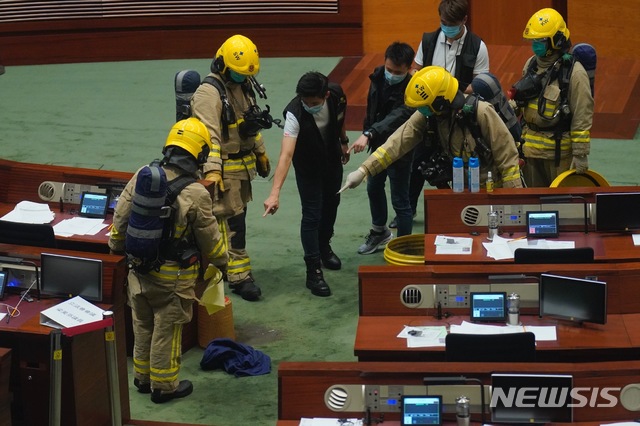 [홍콩=AP/뉴시스] 홍콩 소방대원과 경찰들이 4일 입법회 회의장에서 민주파 의원이 던진 오물을 가르키며 청소작업을 하고 있다. 이 의원은 국가법 제정 논의가 진행되고 있는 입법회에서 "수만년 냄새날 살인정권"이라고 쓴 팻말을 들어올리고 오물통을 던지며 시위를 벌이다가 끌려나갔다. 홍콩 입법회는 이날 국가 모욕을 처벌하는 법안을 통과시킬 예정이다. 2020.06.04 