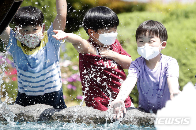 [광주=뉴시스] 신대희 기자 = 폭염 특보가 내려진 지난 4일 광주 북구 용봉동 북구청 광장에 설치된 물레방아 조형물 앞에서 구청 어린이집 원아들이 물놀이를 하고 있다. (사진 = 광주 북구 제공) 2020.06.04. photo@newsis.com