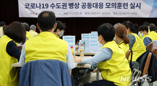 [서울=뉴시스]홍효식 기자 = 5일 오전 서울 중구 국립중앙의료원 연구동에서 열린 '코로나19 수도권 병상 공동대응 모의훈련'에서 참석자들이 자리하고 있다. 이번 모의훈련은 수도권 내 대규모 환자 발생에 대비해 비상상황에서 운영되는 병상 공동대응체계를 사전 점검하고 유관기관간 협력 체계를 구축하기 위해 실시했다. 참석기관은 중앙사고수습본부를 비롯한 소방청, 지차체(서울, 인천, 경기), 국립중앙의료원, 관계기관(협력병원, 공동생활치료센터), 민간 전문가 등 이다. 2020.06.05.&nbsp; yesphoto@newsis.com