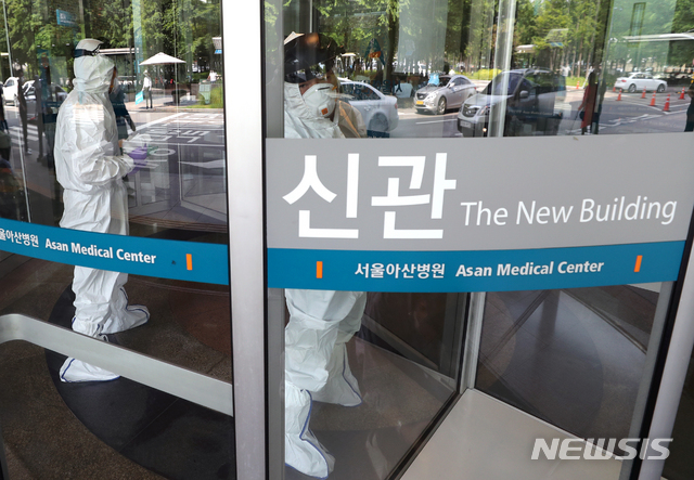 [서울=뉴시스] 이윤청 기자 = 방역 관계자들이 5일 서울 송파구 서울아산병원 신관에서 회전문을 소독하고 있다. 서울아산병원은 5일 신종 코로나바이러스 감염증(코로나) 확진자가 다녀간 것으로 확인돼 신관, 동관 내 일부 시설을 폐쇄하고 소독 조치했다고 밝혔다. 2020.06.05. radiohead@newsis.com