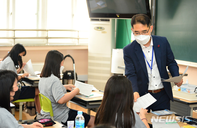 [청주=뉴시스] 인진연 기자 = 마지막 4차 순환등교가 시작된 8일 오전, 충북 청주 경덕중학교 한 교사가 하복을 입고 첫 등교한 1학년 학생들에게 안내사항을 전달하고 있다. 이날 충북에서는 초 5·6, 중1, 약 4만 2000여 명이 첫 등교에 나섰다. 2020.06.08 inphoto@newsis.com 