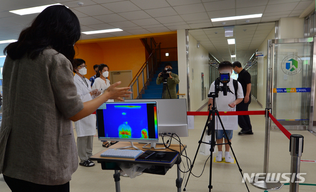 [광주=뉴시스] 변재훈 기자 = 신종 코로나바이러스 감염증(코로나19) 여파로 3개월간 연기됐던 중학교 1학년 등교가 시작된 8일 오전 광주 광산구 고실중학교에서 한 학생이 체온 측정을 하고 있다. 2020.06.08.&nbsp; wisdom21@newsis.com