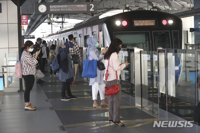 [자카르타=AP/뉴시스] 6월8일 인도네시아 자카르타의 MRT역에서 신종 코로나바이러스 감염증(코로나19) 예방을 위해 마스크를 쓴 승객들이 열차를 기다리고 있다. 인도네시아에서 코로나19 최대 피해 지역인 수도 자카르타는 지난 2개월간의 코로나19 준 봉쇄 조치를 완화했다. 이로써 상점, 식당 등이 수용인원 제한을 두고 개점했으며 오토바이 택시 등의 승객 운송이 재개됐다. 2020.06.08.