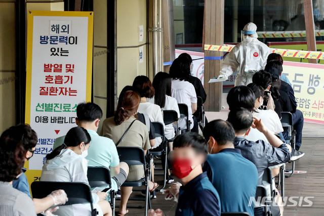 [서울=뉴시스]김병문 기자 = 롯데월드가 지난 5일 중랑구 원묵고등학교 신종 코로나바이러스 감염증(코로나19) 확진 학생의 방문으로 폐쇄된 가운데 8일 오후 서울 송파구 보건소 선별진료소가 검사를 기다리는 시민들로 붐비고 있다. 2020.06.08.  dadazon@newsis.com