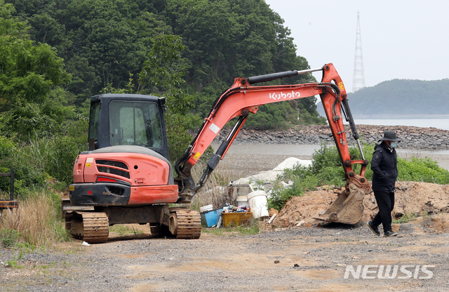 [인천=뉴시스] 이종철 기자 = 대북전단 살포와 관련해 북측이 강경한 입장을 취하며 남북 통신선을 차단하는 등 남북관계가 경색되고 있는 가운데 10일 오전 인천시 강화군 삼산면 석모도 해변에 주민들이 선교단체 회원들의 ‘대북 페트병 보내기’ 행사를 저지하기 위해 세워놓은 굴삭기가 비포장길을 막고 있다. 2020.06.10.&nbsp; jc4321@newsis.com