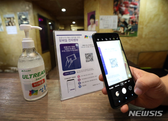 [서울=뉴시스] 박미소 기자 = 노래연습장과 클럽, 헌팅포차 등 고위험시설에 '전자출입명부'가 의무화된 10일 오후 서울 성동구의 한 노래연습장에서 시민이 QR코드를 찍고 있다. 전자출입명부 의무 도입 대상은 정부가 위험도 평가 결과 고위험 시설로 지정한 헌팅포차, 감성주점, 유흥주점, 단란주점, 콜라텍, 노래연습장, 줌바·태보·스피닝 등 실내집단운동, 실내 스탠딩공연장 등 8곳으로 오는 30일까지 계도 기간을 통해 미비 사항을 점검한다.2020.06.10.&nbsp; misocamera@newsis.com 