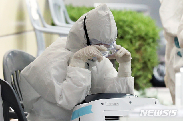 [서울=뉴시스] 이윤청 기자 = 10일 서울 송파구 보건소에서 의료진이 이동식에어컨 앞에서 더위를 식히고 있다. 지난 9일 서울 송파구 강남대성학원 급식실에서 일하는 20대 남성 조리보조원이 신종 코로나바이러스 감염증(코로나19) 확진 판정을 받았다. 10일 송파구에 따르면 학원 수강생과 강사 등 접촉자로 분류됐던 470명을 상대로 진행됐던 코로나19 검사에서 전원 음성 판정이 내려졌다. 2020.06.10.&nbsp; radiohead@newsis.com