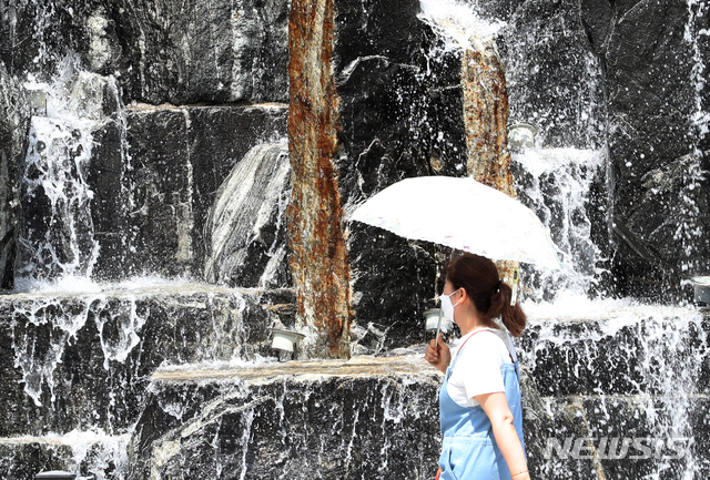 [인천=뉴시스] 이종철 기자 = 더운 날씨를 보인 지난 11일 오전 인천시 남동구 중앙공원에서 시민이 시원하게 내리는 폭포수 앞을 지나가고 있다. 2020.06.11. jc4321@newsis.com