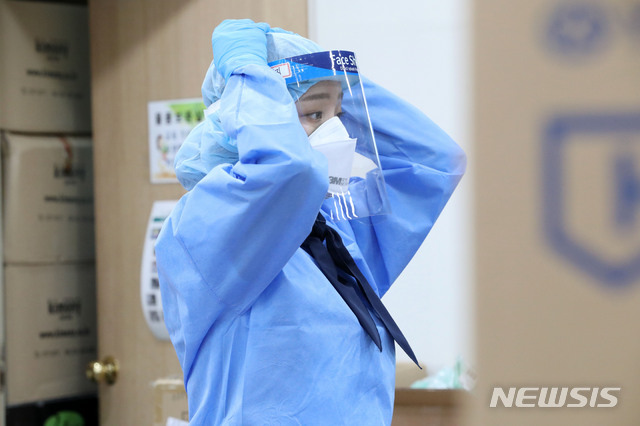 [서울=뉴시스] 박미소 기자 = 서울 한낮 기온이 31도를 기록한 11일 오후 서울 양천구 보건소의 한 의료진이 얼음팩이 든 쿨링 넥밴드를 목에 착용하고 있다. 2020.06.11.&nbsp; misocamera@newsis.com