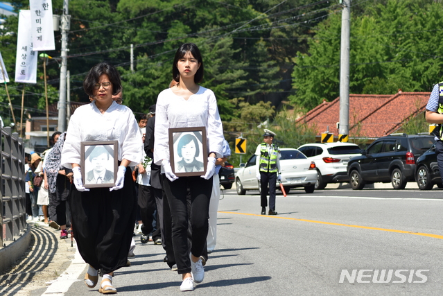 지난해 6월 13일 효순·미선 17주기 추모제에서 추모객들이 신효순·심미선양의 영정 사진과 함께 도로를 따라 행진하고 있다. (사진=효순미선평화공원조성위원회 제공)