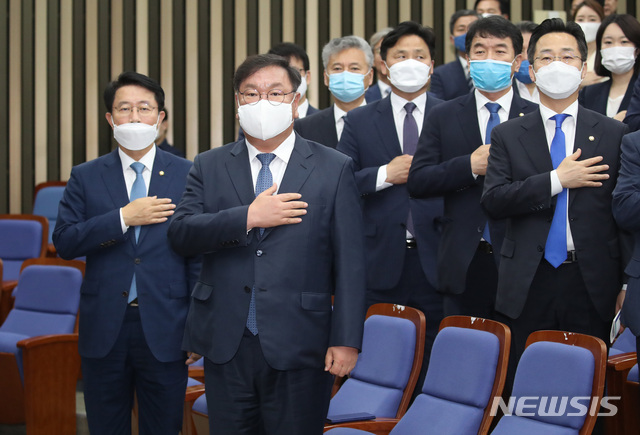 [서울=뉴시스] 김진아 기자 =김태년 더불어민주당 원내대표를 비롯한 의원들이 12일 서울 여의도 국회에서 열린 의원총회에서 국민의례를 하고 있다. 2020.06.12. bluesoda@newsis.com