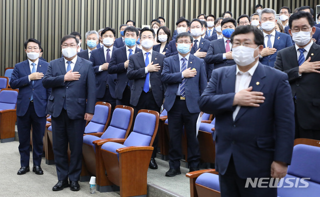 [서울=뉴시스] 김진아 기자 =김태년 더불어민주당 원내대표를 비롯한 의원들이 12일 서울 여의도 국회에서 열린 의원총회에서 국민의례를 하고 있다. 2020.06.12. bluesoda@newsis.com