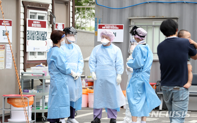 [인천=뉴시스] 이종철 기자 = 신종 코로나바이러스 감염증(코로나19)의 집단감염이 확산되고 무더운 날씨가 계속되는 가운데 12일 오후 인천시 부평구 가톨릭대학교 인천성모병원 선별진료소에서 의료진들이 레벨D 방호복보다 얇고 통풍이 잘 되는 수술용 1회용 가운을 착용하고 의견을 나누고 있다. 2020.06.12. jc4321@newsis.com
