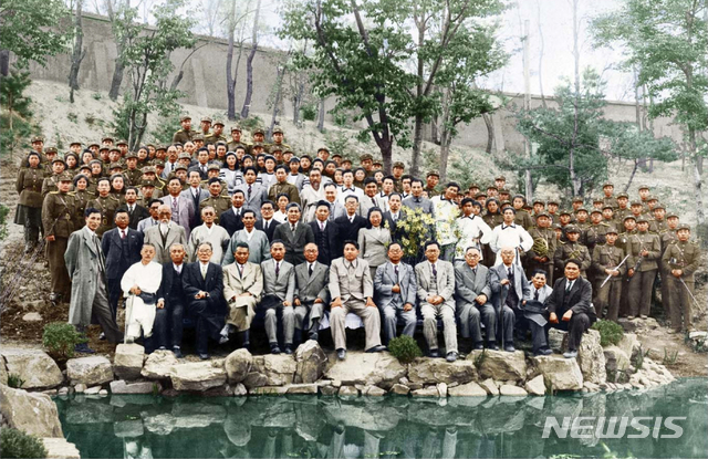 [서울=뉴시스] 1948년 4월 25일 오후 남북제정당·사회단체연석회의 개최 축하 공연을 마치고 주요 간부들과 조선인민군협주단원들이 북조선인민회의 청사 후원에서 기념 촬영을 하고 있다. 1열 왼쪽 세 번째 부터 허헌 남조선노동당 위원장, 김원봉 조선인민공화당 위원장, 이극로 민족자주연맹 정치위원, 김두봉 북조선인민위원회 부위원장, 김일성 북조선인민위원회 위원장, 박헌영 남조선노동당 부위원장 등의 모습이 보인다. 사진 가운데 군복 입은 사람이 정율성 조선인민군협주단장이다. 사진은 북한이 흑색 사진을 컬러사진으로 변환해 공개한 것이다. (사진=미디어한국학 제공) 2020.06.14. photo@newsis.com