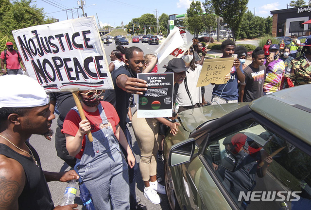 [애틀랜타(미 조지아주)=AP/뉴시스]27살의 흑인 남성 레이셔드 브룩스가 드라이브 스루 라인에서 잠들었다 경찰과 다투던 중 애틀랜타 경찰의 총격으로 숨진 패스트푸드점 웬디스 밖에서 13일 항의 시위가 벌어지고 있다. 2020.6.14 