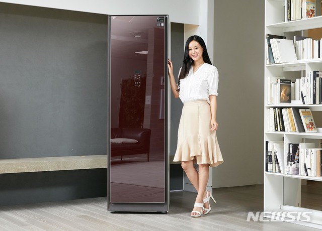 [서울=뉴시스]삼성전자는 의류청정기 에어드레서에 버건디 색상을 적용한 신모델을 15일 출시한다고 밝혔다. 삼성전자 모델이 경기 수원 삼성전자 디지털시티 프리미엄하우스에서 의류청정기 '에어드레서' 신규 색상인 '버건디 미러'를 소개하고 있다. (사진=삼성전자 제공) 2020.06.15. photo@newsis.com