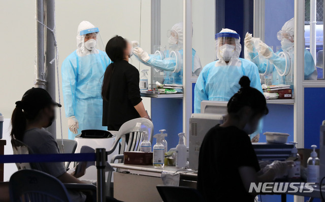 [서울=뉴시스] 고범준 기자 = 의료진들이 15일 오후 서울 송파구 보건소 선별진료소에서 신종 코로나바이러스 감염증(코로나19) 검체를 채취하고 있다. 지난 13일 서울 송파구 소재 롯데택배 동남권물류센터에서 코로나19 확진자가 발생한 가운데 이날 해당 건물은 폐쇄조치 됐다. 2020.06.15.&nbsp; bjko@newsis.com