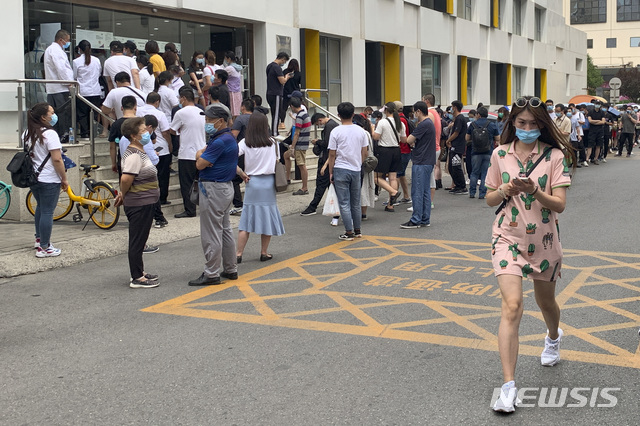 [베이징=AP/뉴시스]최근 중국 베이징의 대형농수산물 시장에서 신종 코로나바이러스 감염증(코로나19) 집단 발병 사태 여파가 최소 3개 성으로 확산한 가운데 15일(현지시간) 베이징의 보건소 앞에서 핵산 증폭 검사를 받으려는 시민들이 마스크를 쓰고 줄 서 있다. 베이징에서 코로나19 확진 사례가 증가하면서 중국 내에서 베이징 방문자에 대한 관리를 강화하고, 베이징 방문을 자제시키고 있다. 2020.06.15.
